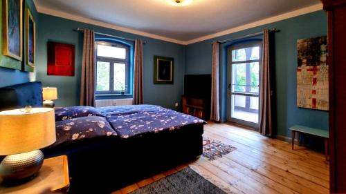 a bedroom with a bed with blue walls and windows at Fewo ROSE in Porschdorf