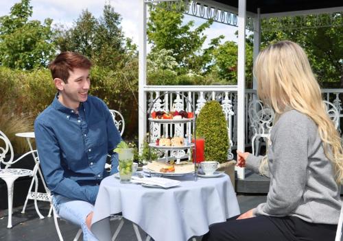 a man and a woman sitting at a table with a cake at Ashdown Park Hotel in Gorey
