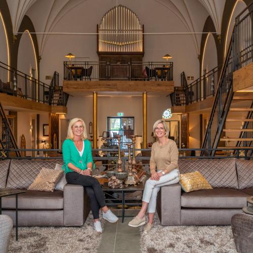 two women sitting on chairs in a lobby at KerkHotel Biervliet in Biervliet