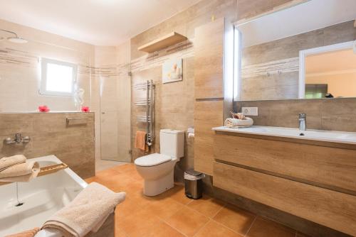 a bathroom with a toilet and a sink and a tub at Villa Dolce Vita in Portocolom