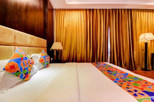a bedroom with a large bed with colorful pillows at Oriva Suvee Boutique Banashankari in Bengaluru