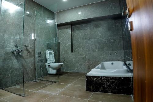 y baño con ducha, lavabo y aseo. en MPSROYALSUITES, en Perintalmanna