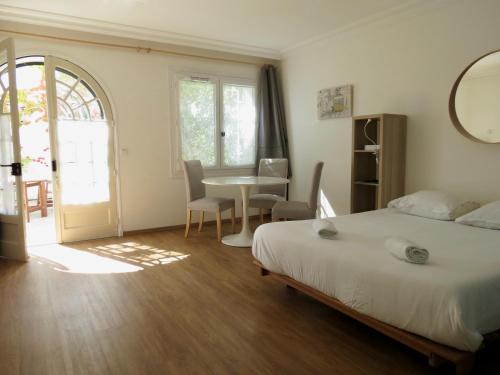 um quarto com uma cama e uma mesa com cadeiras em La Chambre Bleue em Saint-Aignan