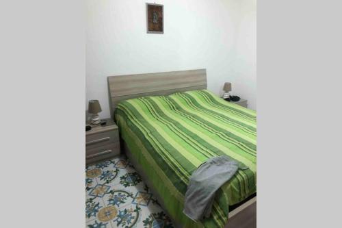 1 dormitorio con 1 cama con edredón verde en AffIttasi Casa Giuseppe, en Procida