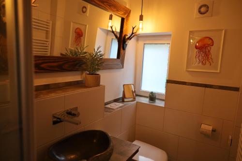 łazienka z umywalką, toaletą i oknem w obiekcie Appartement 'Oachkatzl' w mieście Grossvolderberg