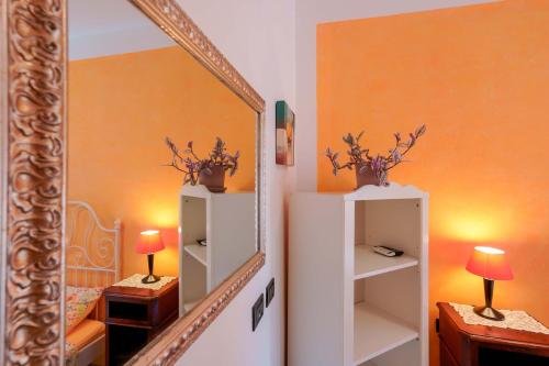 a room with a mirror and a white refrigerator at A Casa Fachin Room & Breakfast in Bologna
