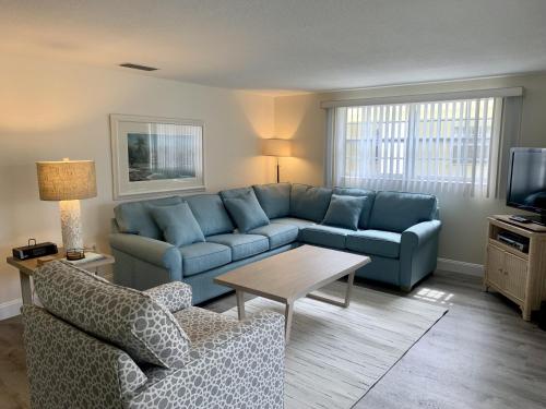 a living room with a blue couch and a table at Island House Beach Resort 34 in Siesta Key