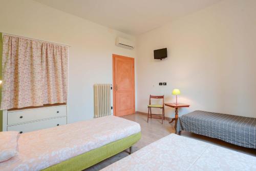 a room with two beds and a television and a table at A Casa Fachin Room & Breakfast in Bologna