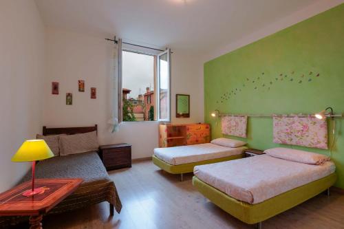 a room with two beds and a couch and a window at A Casa Fachin Room & Breakfast in Bologna