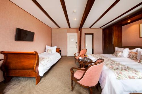 a hotel room with two beds and a tv at Hotel Regina in Wengen