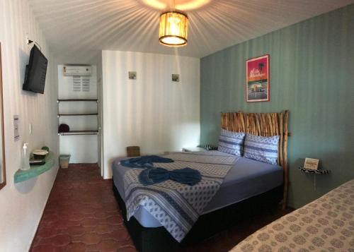 ein Schlafzimmer mit einem Bett in einem Zimmer in der Unterkunft Pousada o Mineiro Central in Galinhos