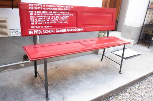 einer roten Bank, die vor einem Schild sitzt in der Unterkunft B&B Vacanze in Mugello in San Piero a Sieve