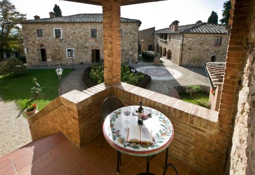 a patio with a table and chairs and a building at Relais Riserva di Fizzano in Castellina in Chianti