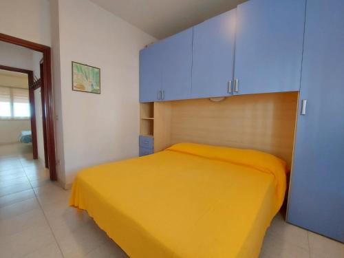a bedroom with a yellow bed and blue cabinets at Pagoda 4 in Lido di Pomposa
