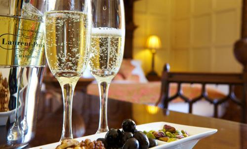 two champagne glasses on a table with a plate of food at The Wrea Head Hall Country House Hotel & Restaurant in Scarborough