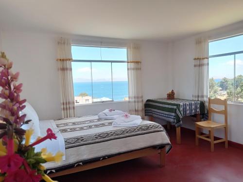 a bedroom with two beds and a large window at Hospedaje y Restaurante Saywa in Llachon