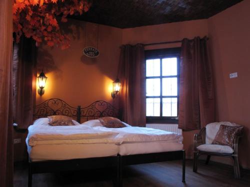 a bedroom with a large bed and a window at Penzion Fermata in Ostrava