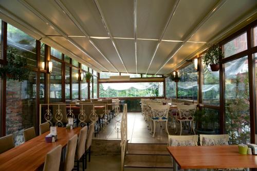 un restaurante con mesas, sillas y ventanas en Tashkonak Studio Suites, en Estambul