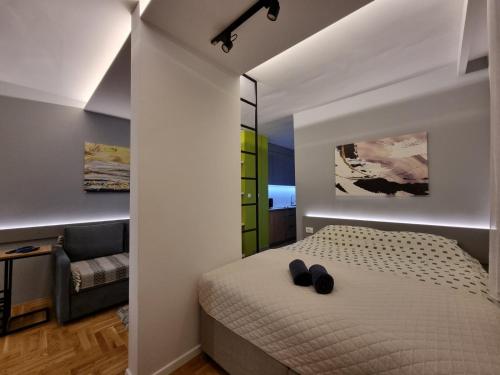 a bedroom with a bed with black shoes on it at Apartman Golden Lux 1 in Pale