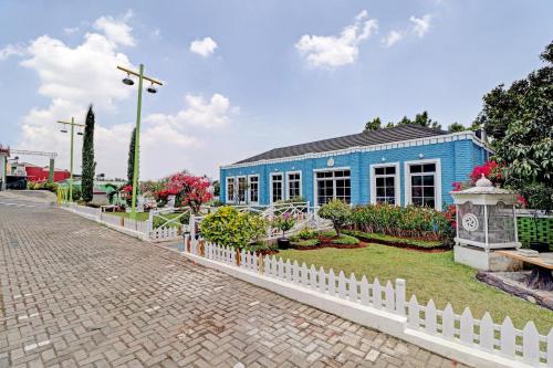 a blue building with a white fence in front of it at Collection O 90617 Rumah Oma Opa Syariah in Bandung