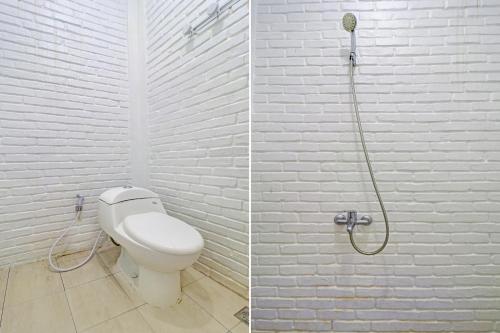 a white bathroom with a toilet and a shower at Collection O 90617 Rumah Oma Opa Syariah in Bandung