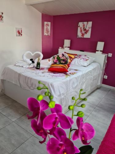 レ・ゼペスにあるStudio Le Pavachon 2 à 3 couchages, piscine familiale chauffée, 3 min du Puy du Fou Les Epessesの紫の壁と紫の花のベッドが備わるベッドルーム1室が備わります。