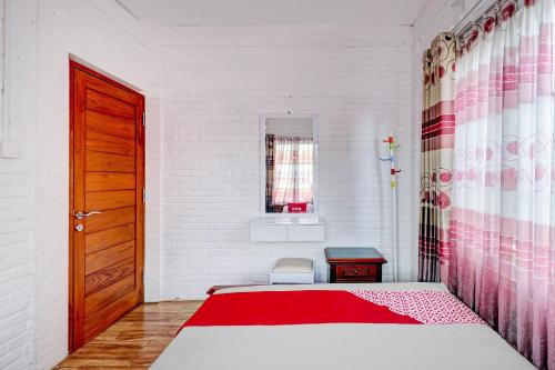 a bedroom with a bed and a red door at Collection O 90617 Rumah Oma Opa Syariah in Bandung