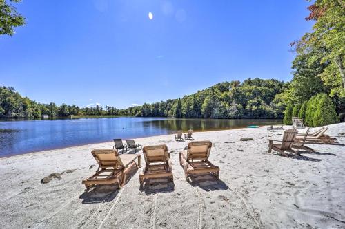 a group of chairs on a beach next to a lake at 9 Mi to Sugar Mountain Newland Cabin with Fire Pit! in Newland