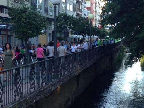 a crowd of people walking over a bridge over a river at Pensión-Albergue Puente Ribeira in Sarria