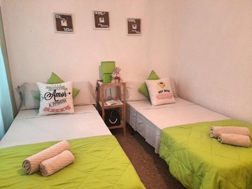 コルドバにあるApartamento Patios de San Lorenzoの緑と白のシーツが備わる客室のベッド2台