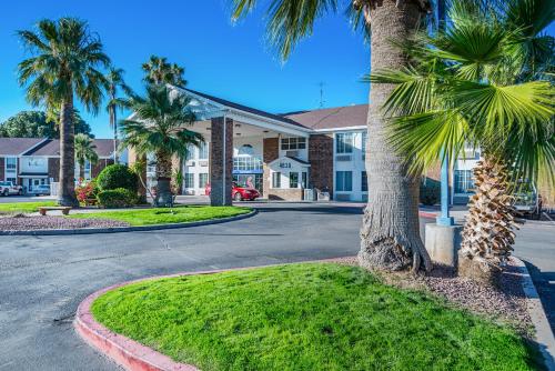 a street in front of a building with palm trees at Studio 6 Tucson, AZ - North in Tucson