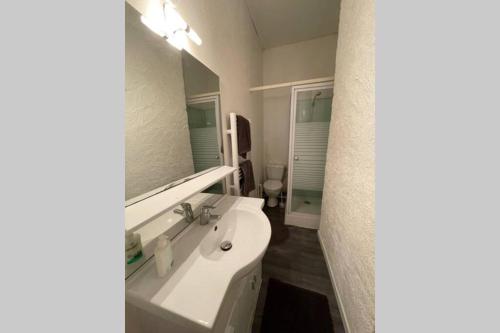 uma casa de banho com um lavatório e um espelho em YIN YANG em Niort