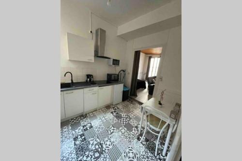 uma cozinha com armários brancos e um piso preto e branco em YIN YANG em Niort