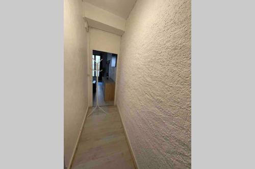 um corredor com uma parede branca e uma porta em YIN YANG em Niort