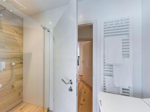 a white bathroom with a shower and a toilet at Lieblingsort in Garmisch-Partenkirchen