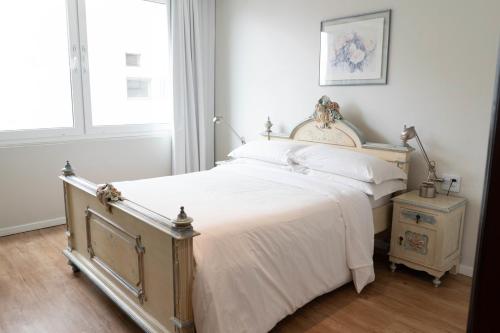 a bedroom with a bed with white sheets and a window at Plaza São Rafael Hotel in Porto Alegre