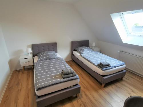 2 Einzelbetten in einem Zimmer mit Fenster in der Unterkunft Ferien in Sarstedt am Bruchgraben in Sarstedt