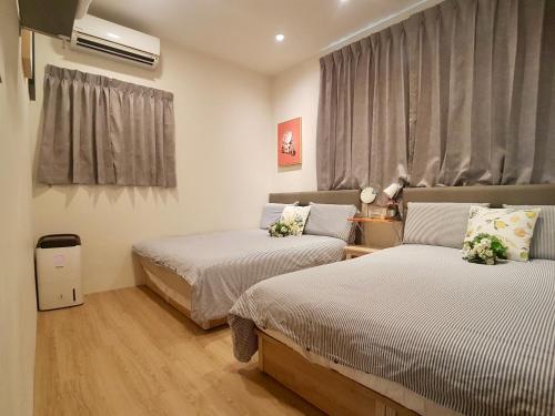 a bedroom with two beds and a window at 高雄好日子914包棟KTv民宿 in Kaohsiung