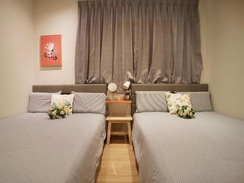 two beds in a room with a window at 高雄好日子914包棟KTv民宿 in Kaohsiung
