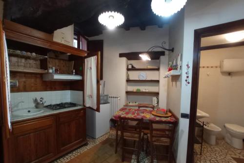 eine kleine Küche mit einem Tisch und einem Waschbecken in der Unterkunft Casa Paola in Spoleto
