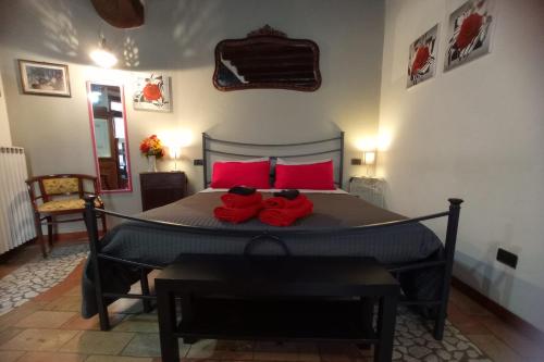 um quarto com uma cama grande e almofadas vermelhas em Casa Paola em Spoleto