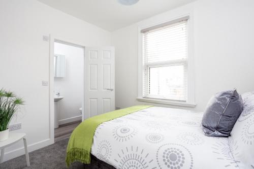 a white bedroom with a bed and a window at Whole house in centre of Town Ideal for Contractors and Professionals in Normanton