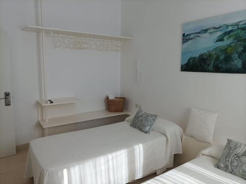 Cette chambre blanche comprend deux lits et un canapé. dans l'établissement CASA RURAL ALCALDE RIVERA, à La Carrasca