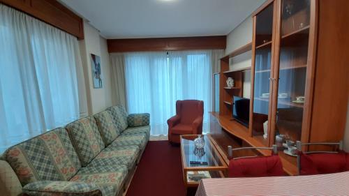 a living room with a couch and a television at Apartamento in Ferrol