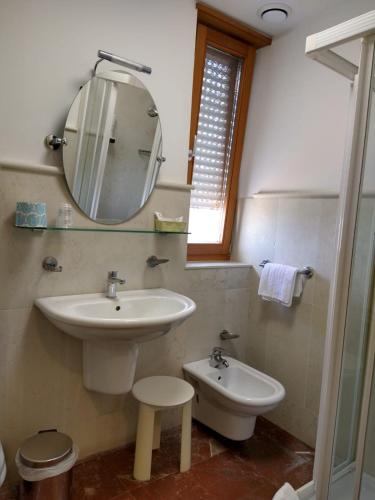 a bathroom with a sink and a mirror and a toilet at Hotel Centrale in Lido di Jesolo