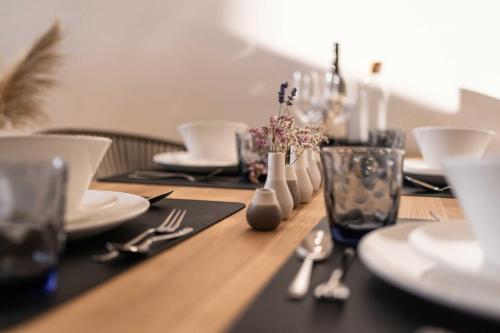 a wooden table with plates and utensils on it at Weinberg Chalet Klöch in Klöch