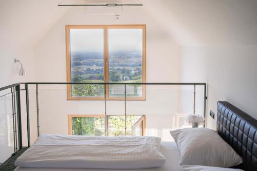 a bedroom with a bed with a large window at Weinberg Chalet Klöch in Klöch