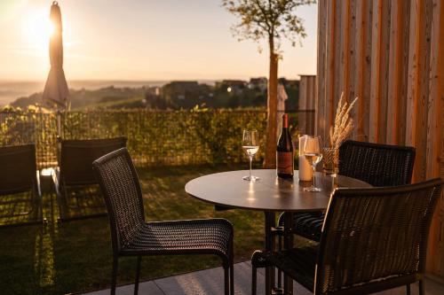a table and chairs with wine glasses on a patio at Weinberg Chalet Klöch in Klöch