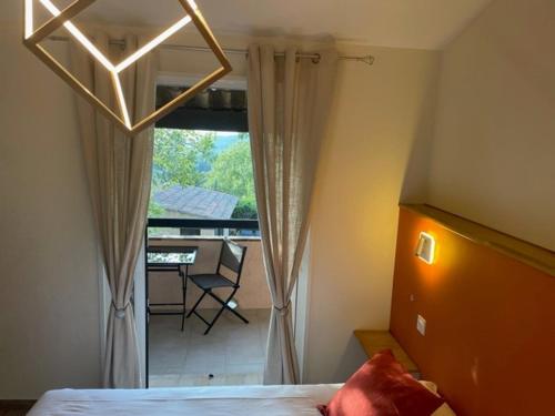a bedroom with a bed and a view of a balcony at L'Estirado des Adrets in Les Adrets de l'Esterel