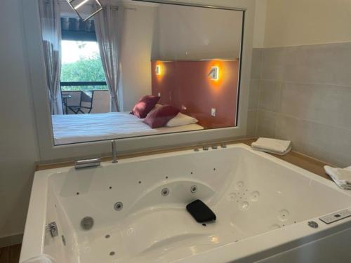 a bathroom with a large bath tub with a large mirror at L'Estirado des Adrets in Les Adrets de l'Esterel